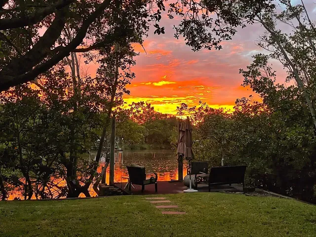 a living room with furniture and a dining table with wooden floor