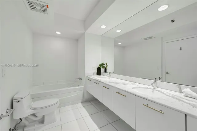 a bathroom with a granite countertop sink a toilet and bathtub