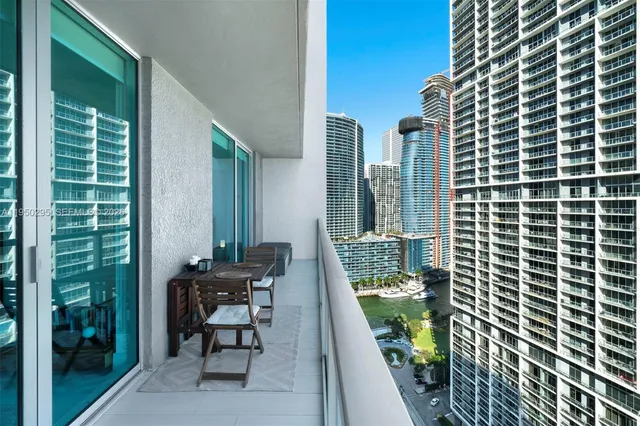 a balcony with chairs and a potted plant