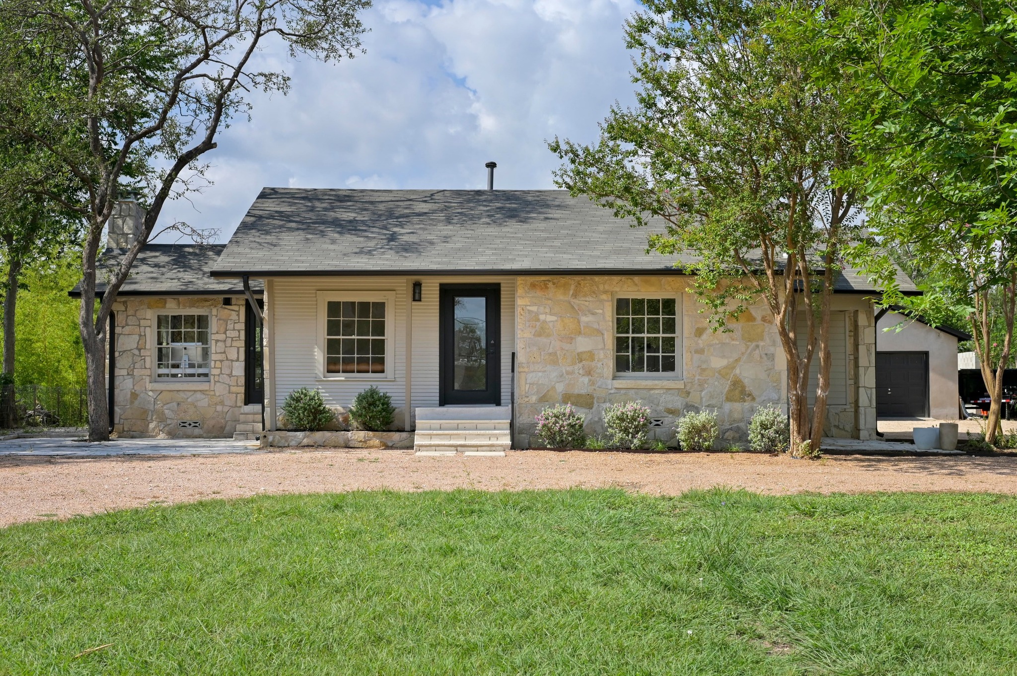3501 Pecan Springs Road Austin, TX 78723 - Photo 3 of 40 View of front facade featuring stone siding, a front lawn, and roof with shingles