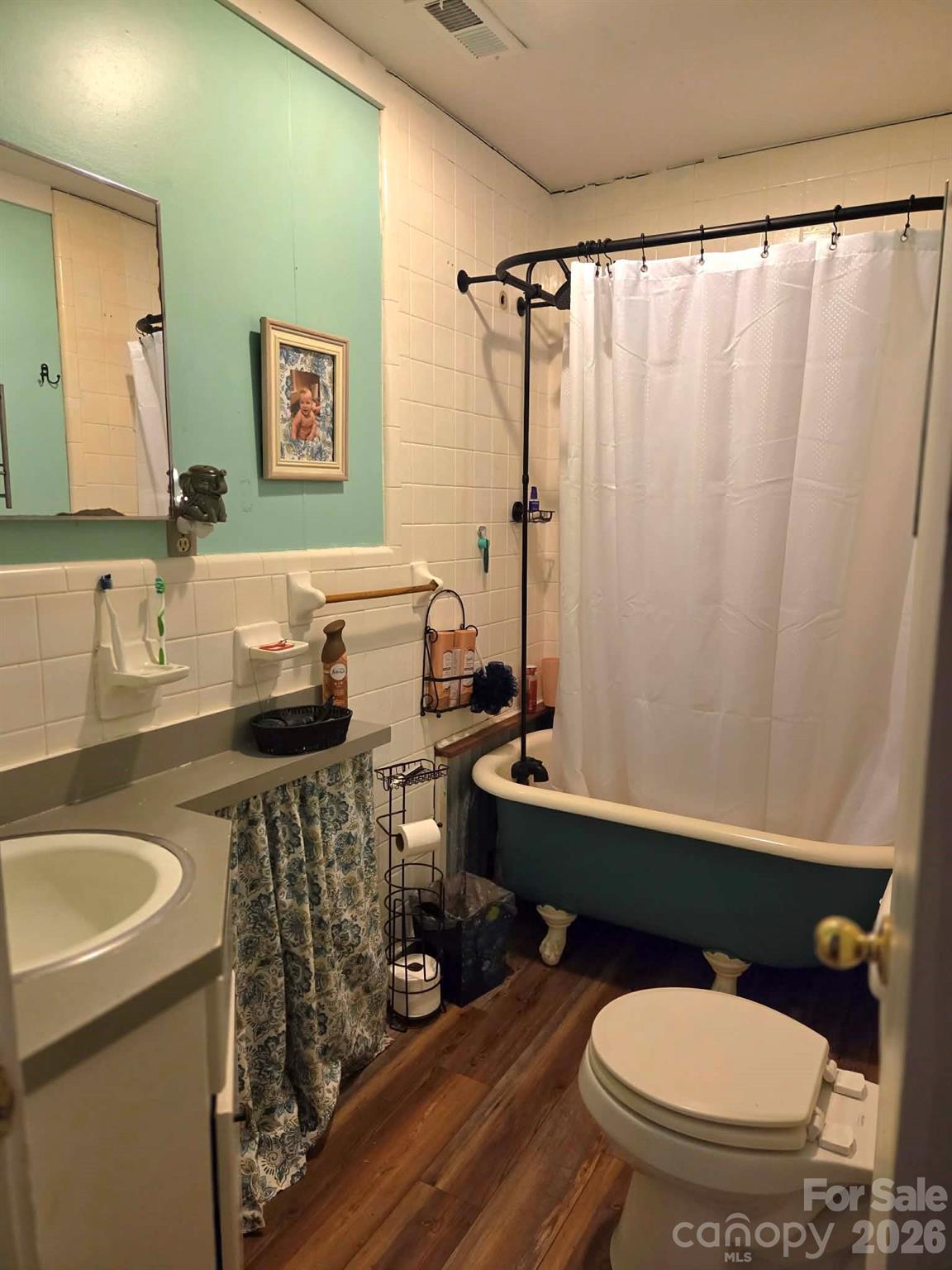 8772 Honeycutt Road Stanfield, NC 28163 - Photo 7 of 7 a bathroom with a sink a toilet a mirror and shower curtain