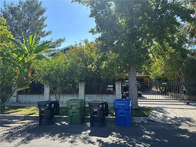 a view of a patio with table and chairs potted plants and large tree