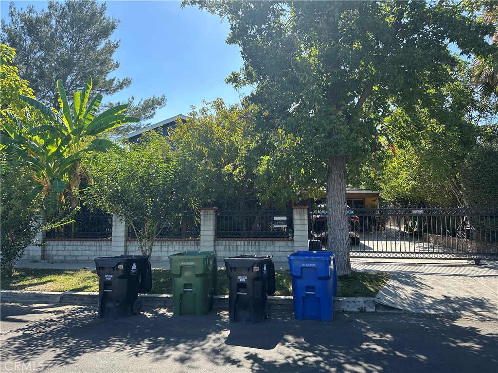 a view of a patio with table and chairs potted plants and large tree
