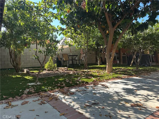 a view of a backyard with table and chairs and potted plants