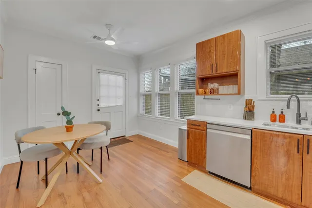 a kitchen with stainless steel appliances wooden floors and white cabinets