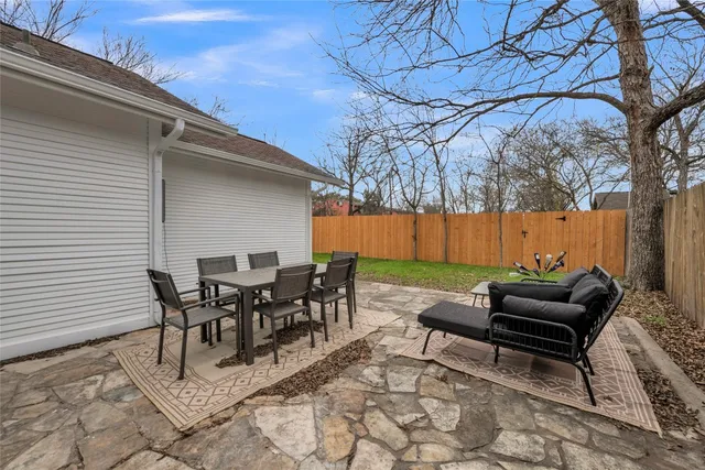 a view of a patio with table and chairs and floor to ceiling window