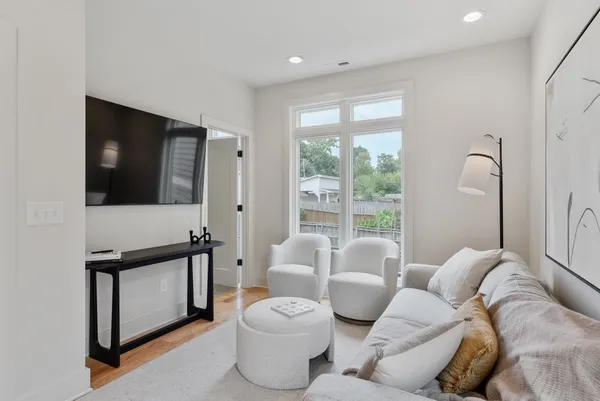a living room with furniture a window and a flat screen tv