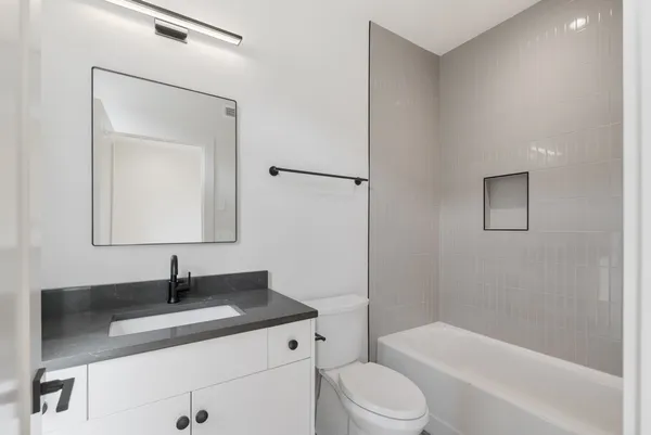a bathroom with a granite countertop sink toilet and shower