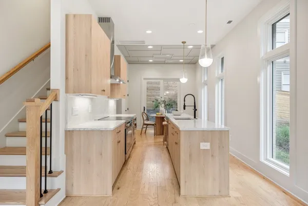 a large kitchen with stainless steel appliances kitchen island granite countertop a sink and cabinets