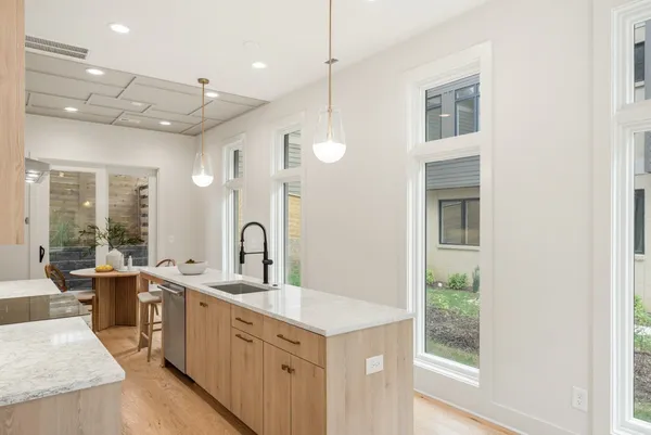 a kitchen with a sink a counter top space and living room area