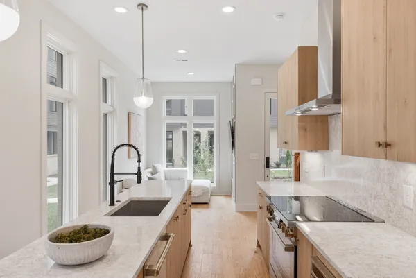 a kitchen with stainless steel appliances granite countertop a sink and a stove with white countertops