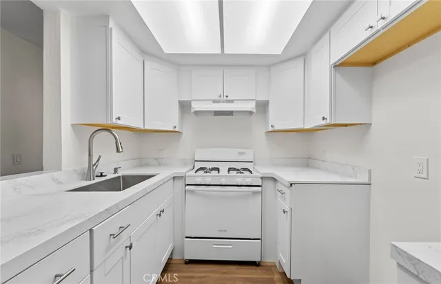 a kitchen with granite countertop white cabinets and white appliances