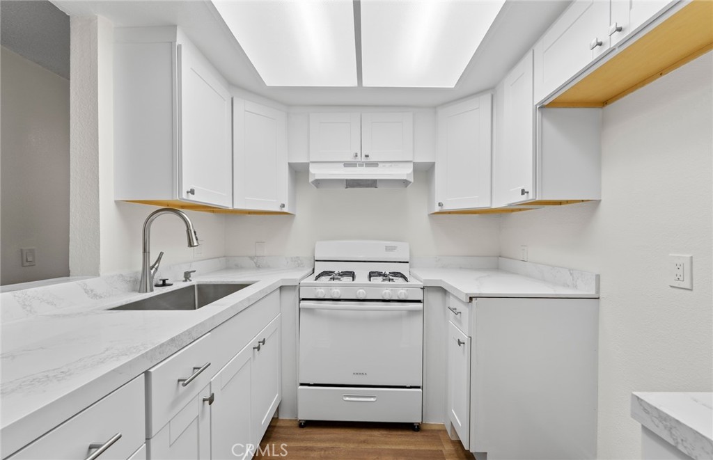 a kitchen with granite countertop white cabinets and white appliances