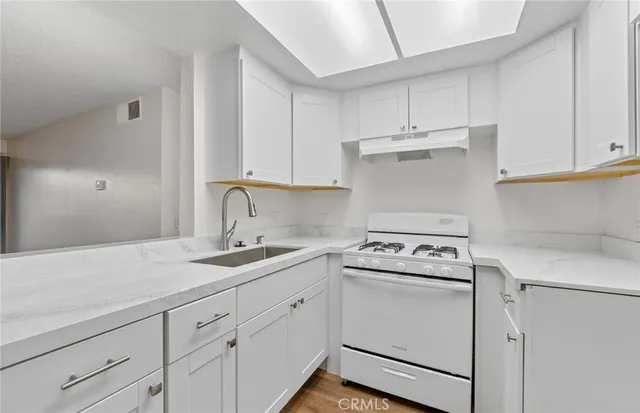 a kitchen with cabinets appliances a sink and a counter top