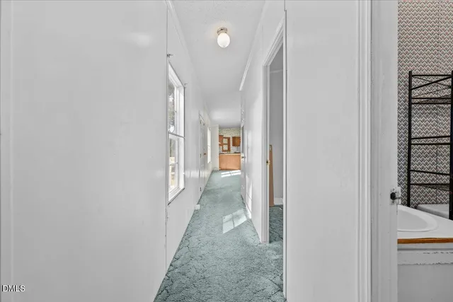 a view of a hallway with wooden floor and entryway
