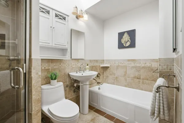 a bathroom with a sink a toilet and shower