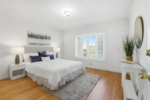 a bedroom with bed and a potted plant