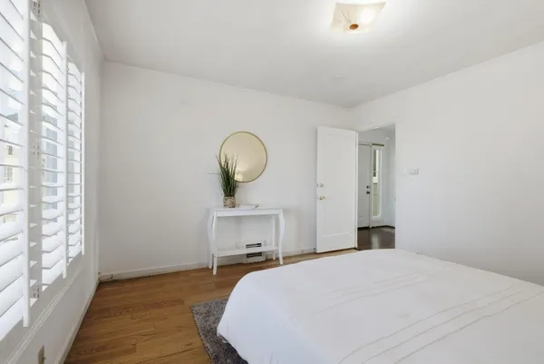 a bedroom with a bed and wooden floor