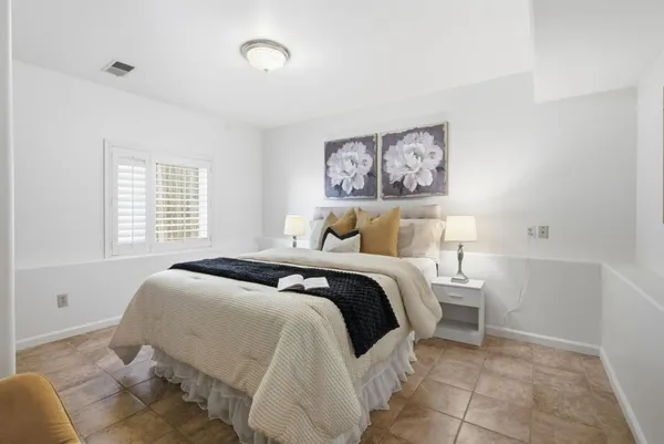 a bedroom with a bed and a window