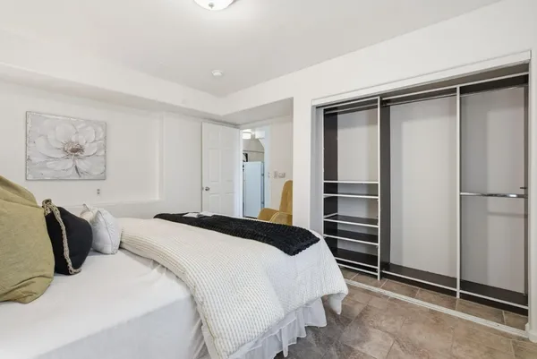 a bedroom with a bed and a refrigerator