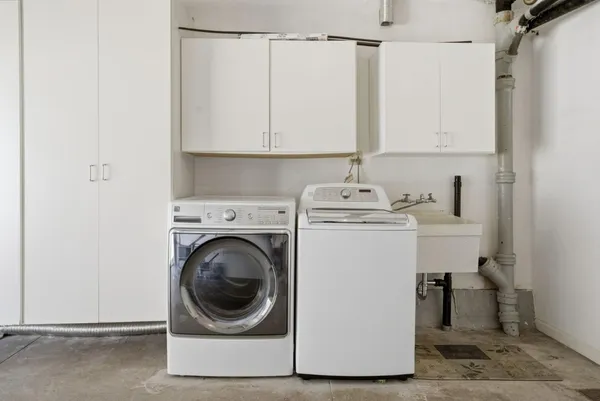a utility room with sink dryer and washer