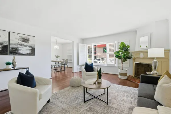 a living room with furniture a fireplace and a potted plant