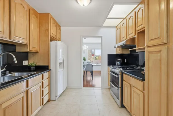 a kitchen with stainless steel appliances granite countertop a stove a sink and a refrigerator