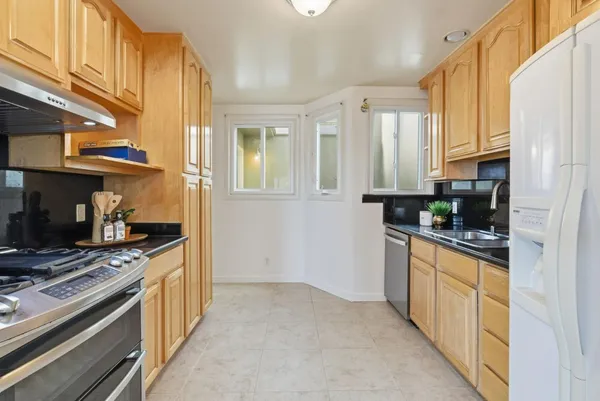a kitchen with stainless steel appliances granite countertop a stove a sink and a refrigerator