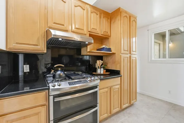 a kitchen with stainless steel appliances granite countertop a stove and a refrigerator