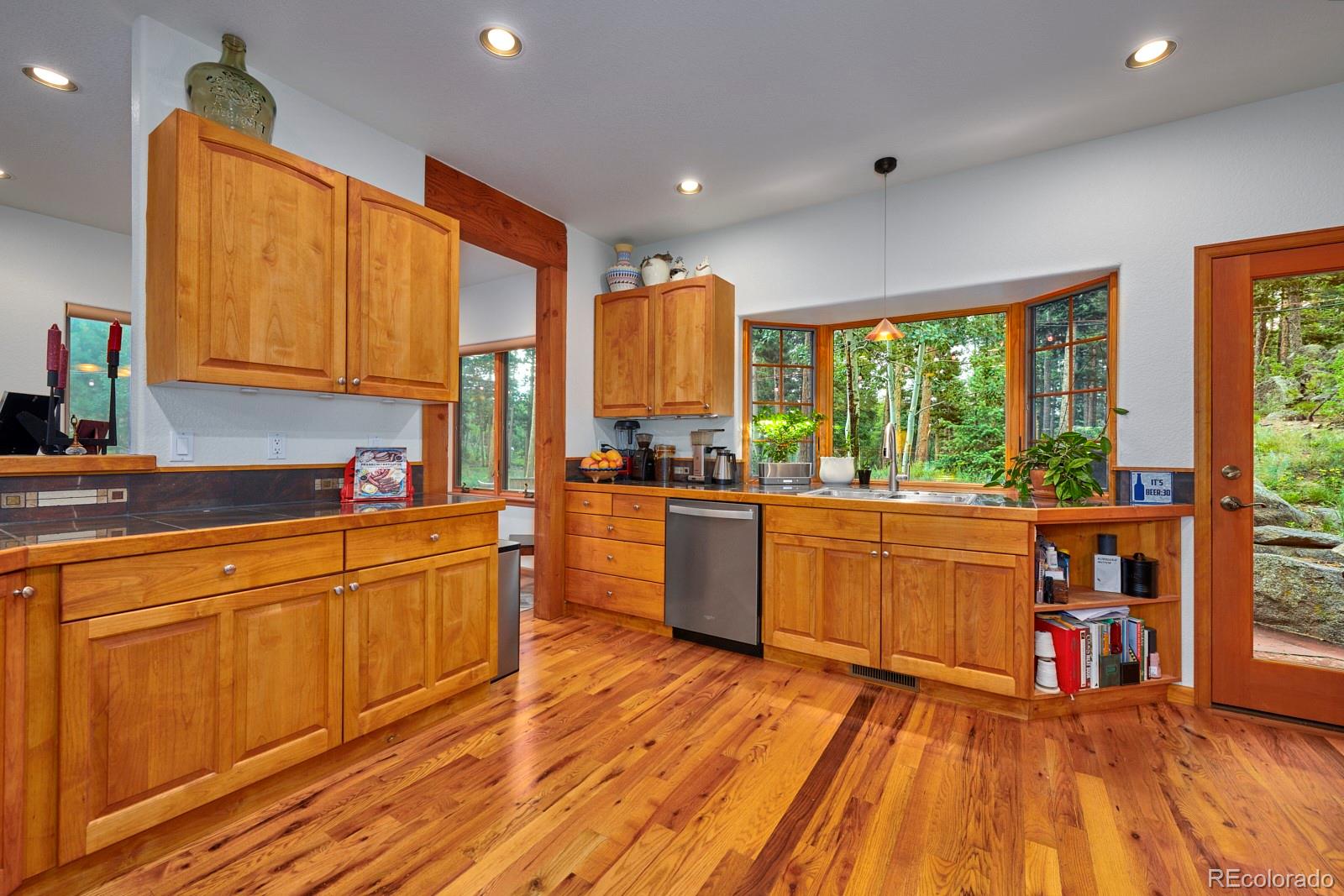3589 Ridge Road Nederland, CO 80466 - Photo 12 of 40 a large kitchen with stainless steel appliances wooden floors and wooden cabinets