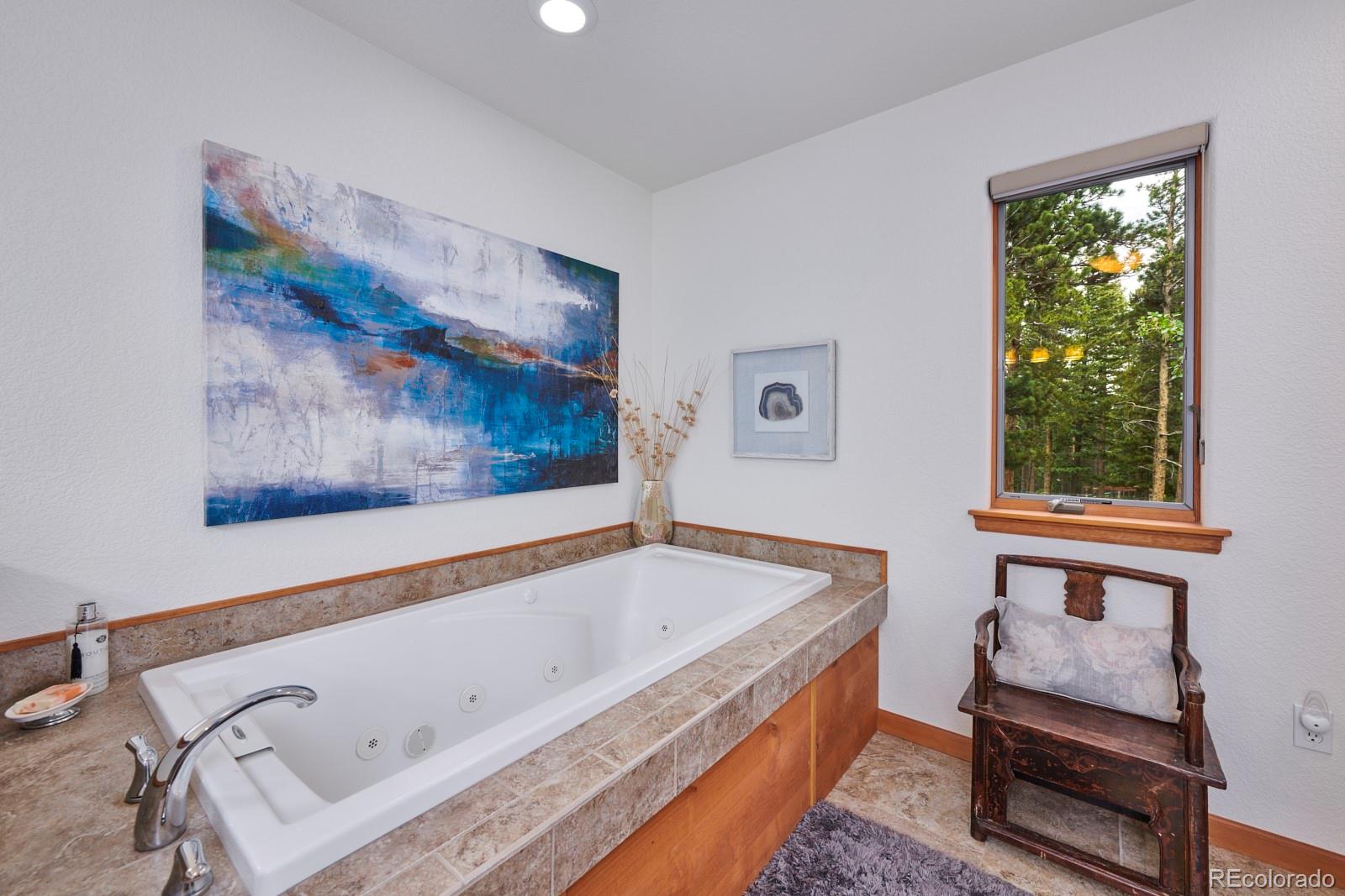 3589 Ridge Road Nederland, CO 80466 - Photo 24 of 40 a bathroom with a tub and a painting on the wall