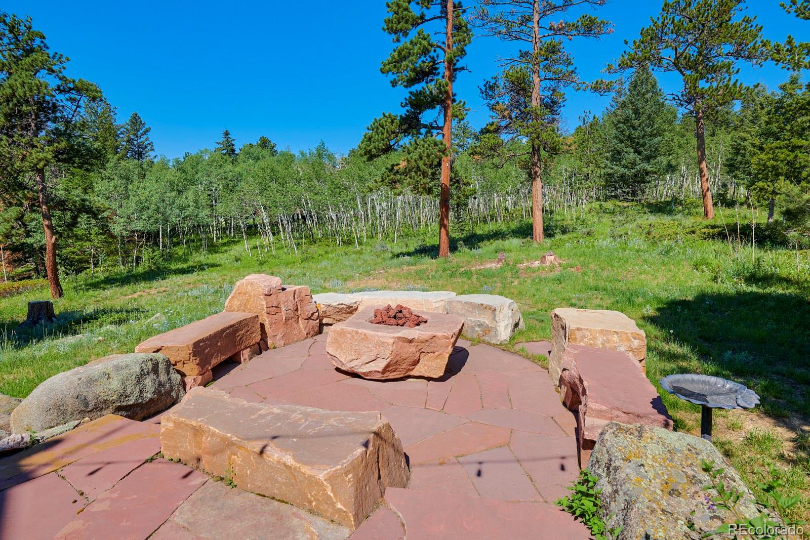 3589 Ridge Road Nederland, CO 80466 - Photo 30 of 40 a view of a patio with a table and chairs potted plants and large tree