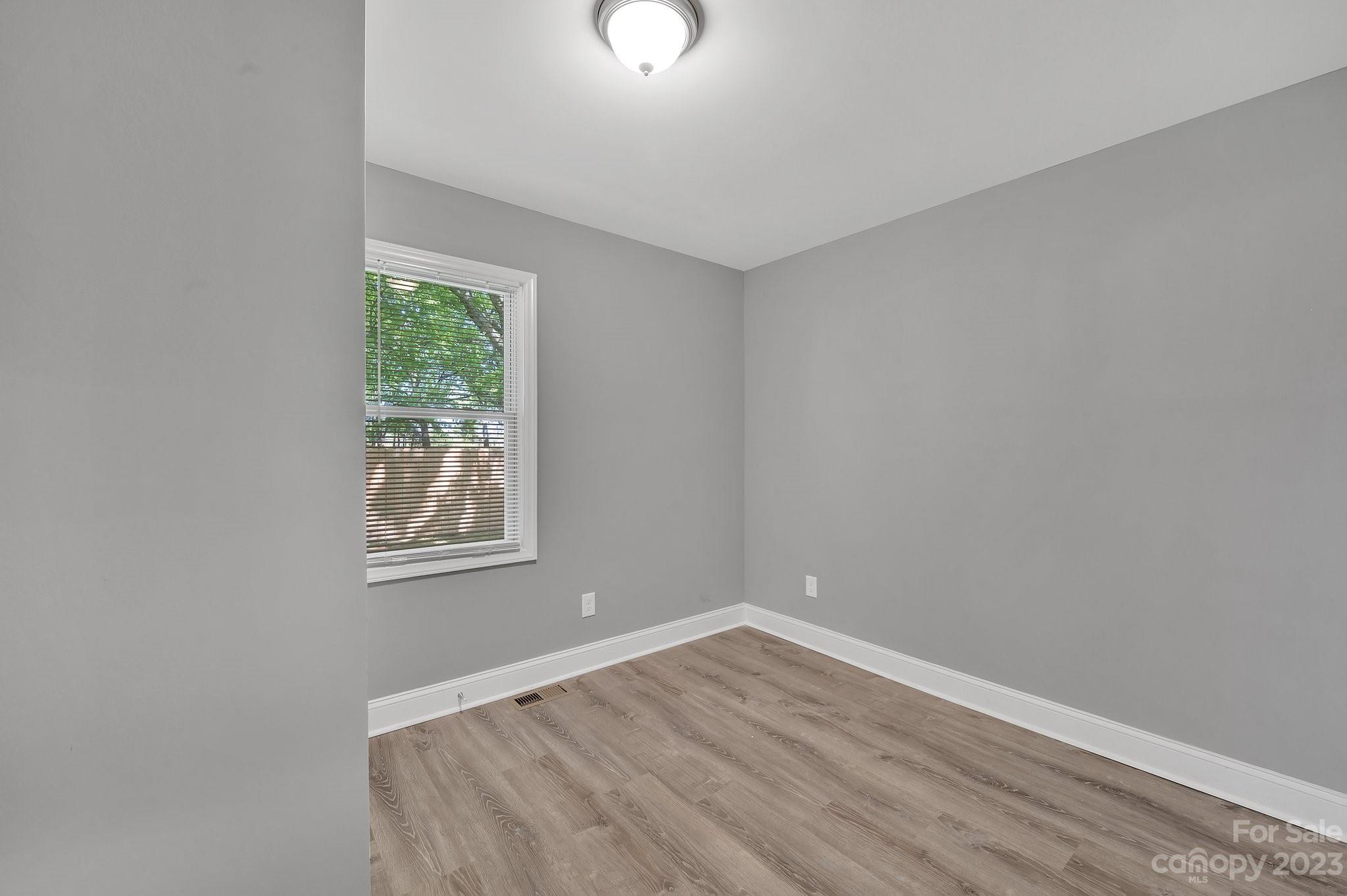 128 Jeter Street Chester, SC 29706 - Photo 11 of 20 an empty room with wooden floor and windows