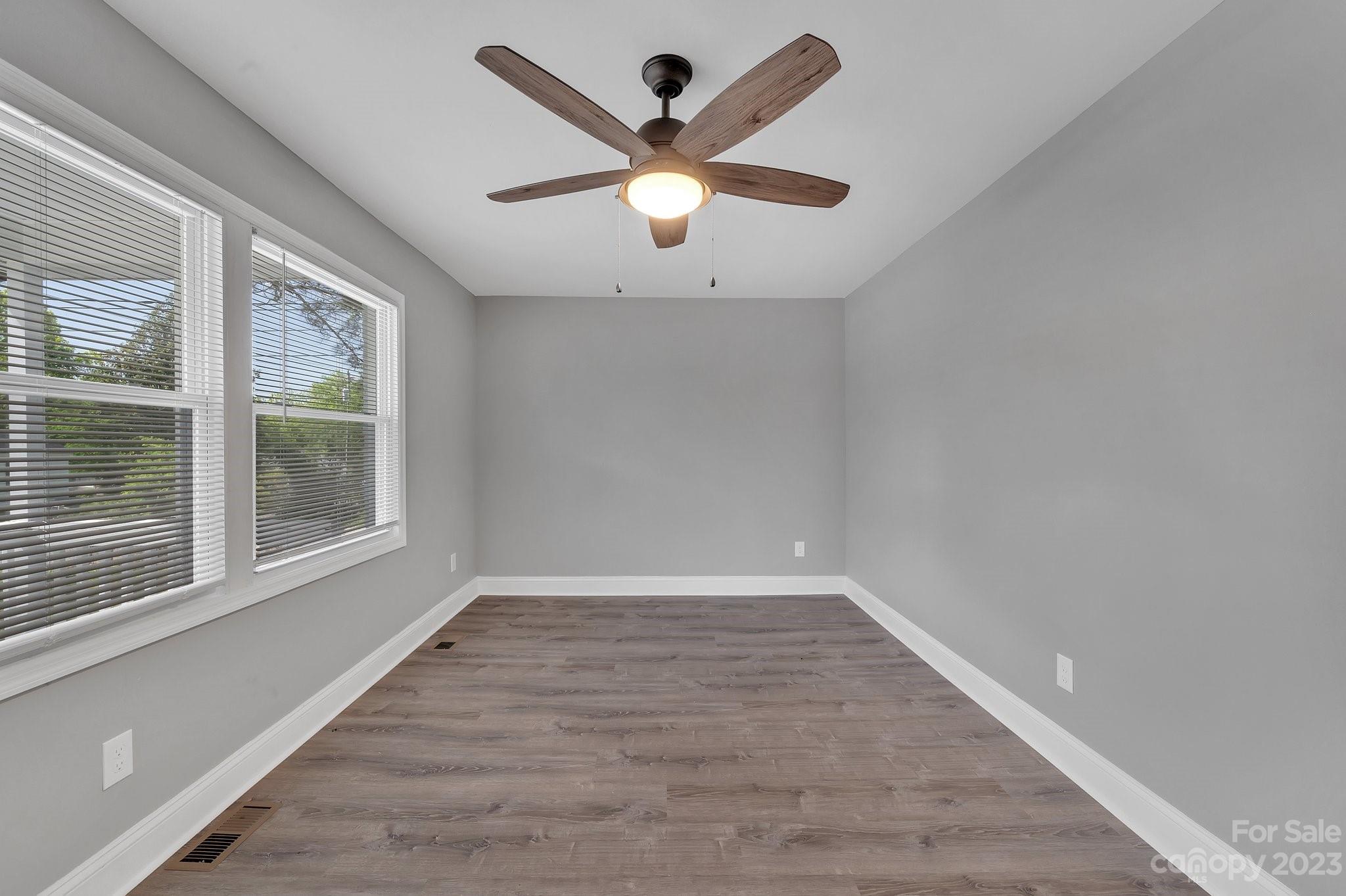 128 Jeter Street Chester, SC 29706 - Photo 3 of 20 an empty room with wooden floor and windows