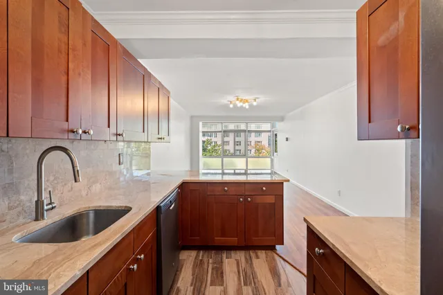 a kitchen with granite countertop a sink a counter space and cabinets