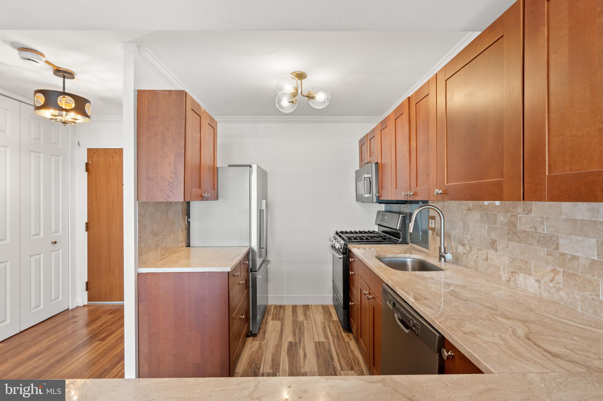 730 24th Street Northwest, Unit 503 Washington, DC 20037 - Photo 3 of 18 a kitchen with stainless steel appliances granite countertop a sink a stove and a wooden floors