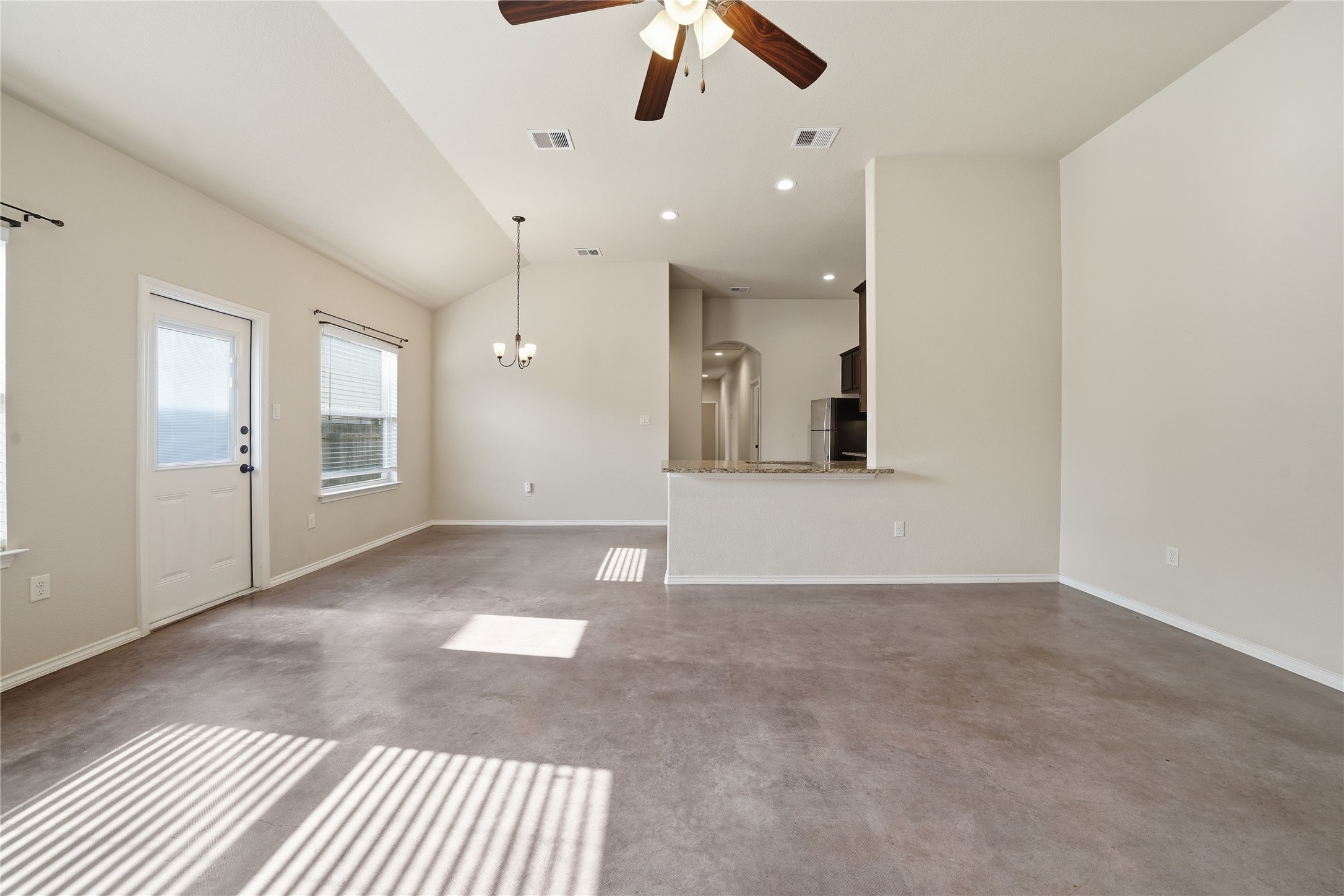 533 Jack Rabbit Lane, Unit A Buda, TX 78610 - Photo 13 of 34 A well-lit, open-concept living space with lofty ceilings and a convenient breakfast bar.