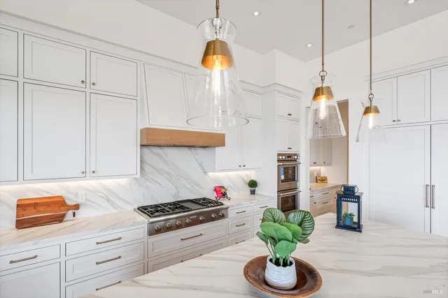 a kitchen with stainless steel appliances granite countertop a sink a stove and a wooden floors
