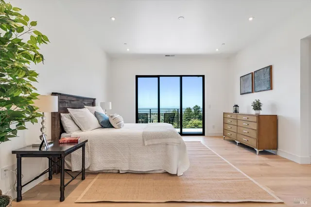 a bedroom with a large bed and a potted plant