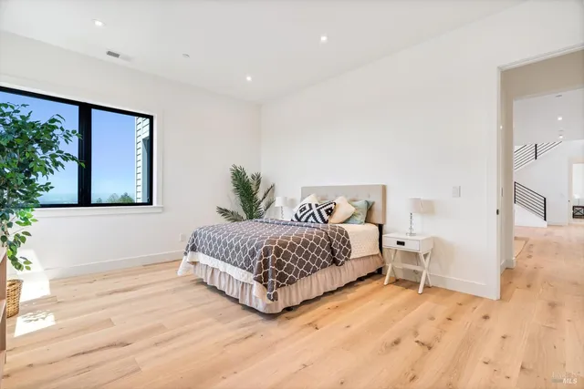 a bedroom with a large bed and a potted plant