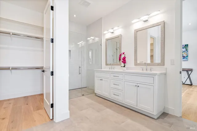 a bathroom with a shower sink vanity and mirror