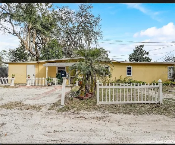 a view of a house with a yard and wooden fence