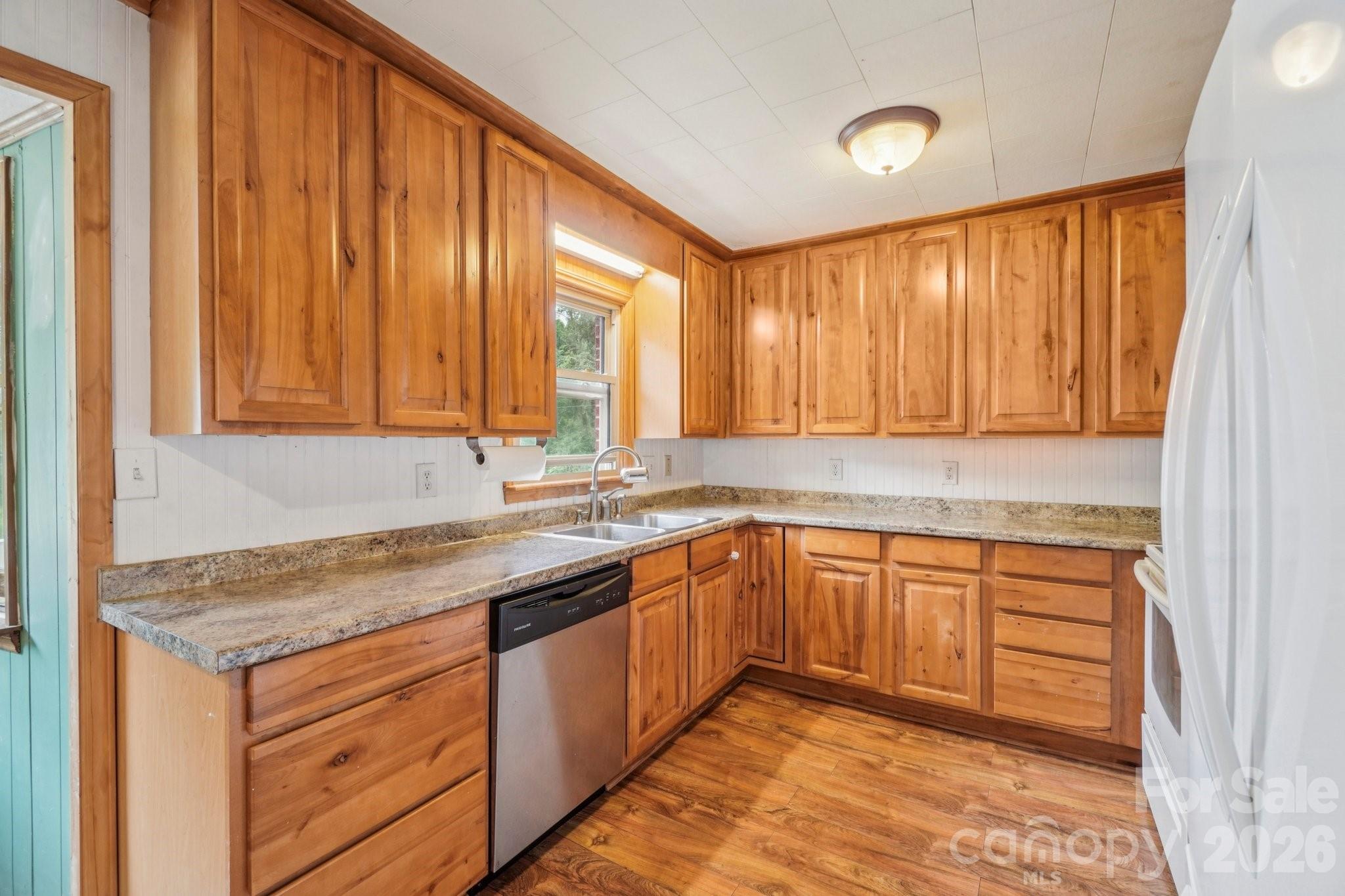 8061 Highway 70 Old Fort, NC 28762 - Photo 10 of 37 a kitchen with stainless steel appliances granite countertop wooden cabinets a sink and dishwasher with wooden floor