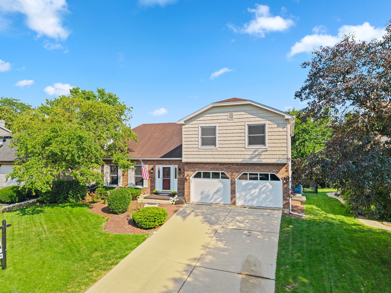 a front view of a house with yard and green space