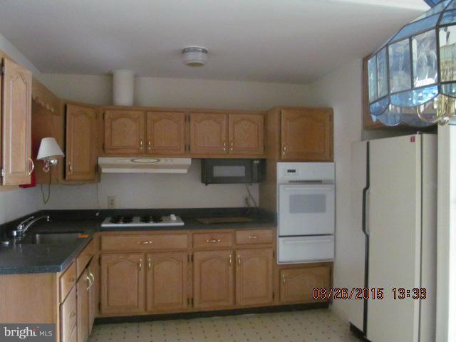 109 South Bend Road Glen Burnie, MD 21060 - Photo 3 of 21 a kitchen with granite countertop a refrigerator and a sink