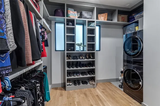 a view of walk in closet with clothes and shoes