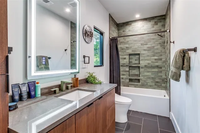 a bathroom with a granite countertop sink toilet and shower