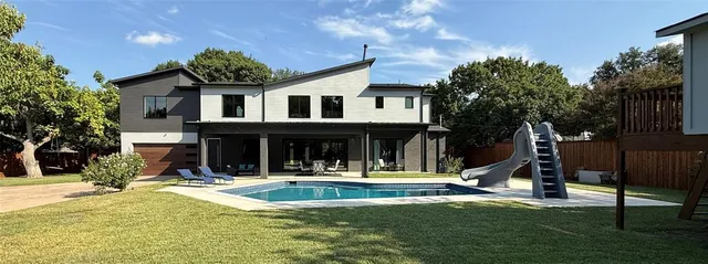 a front view of a house with swimming pool and sitting area