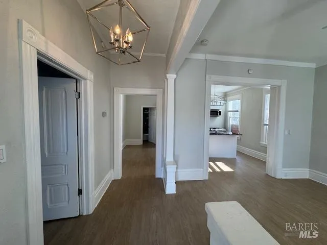 a view of a hallway with wooden floor and a living room
