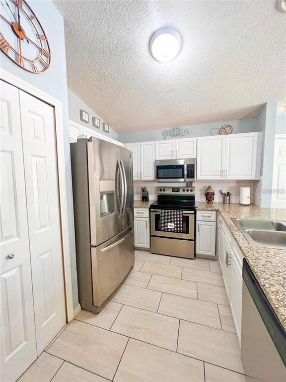 307 Diamond Ridge Boulevard Auburndale, FL 33823 - Photo 11 of 31 a kitchen with stainless steel appliances granite countertop a refrigerator sink and cabinets